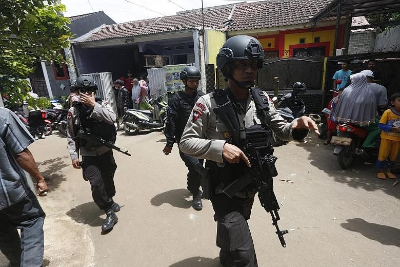 Indonesian anti-terror policemen conducting a raid in a residential area in South Tangerang, a city 25km outside Jakarta, yesterday.