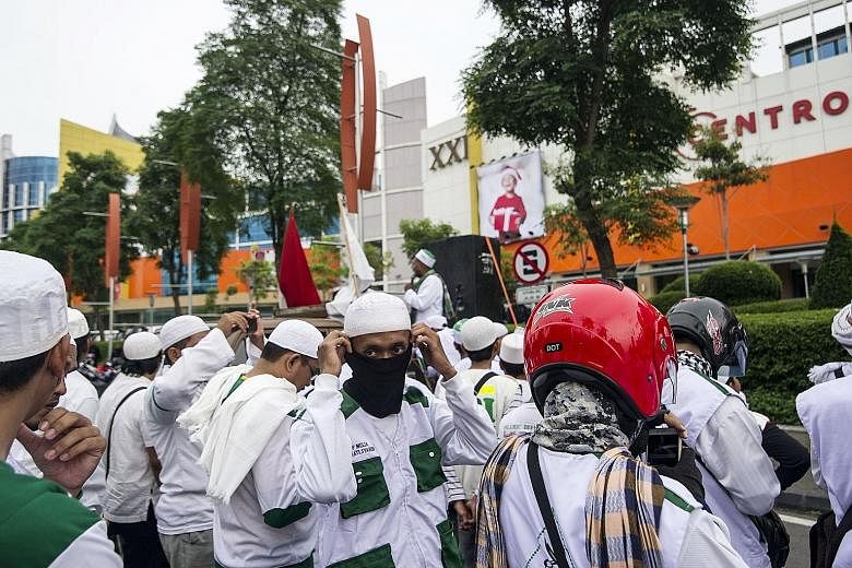 Protesters from the hardline Islamic Defenders Front demonstrating outside a mall in Surabaya on Sunday to stop retail workers from wearing Santa hats in shopping malls. The Indonesian Ulema Council recently issued an edict banning Muslims from weari