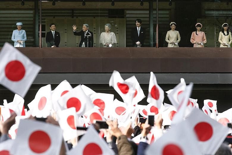 Emperor Akihito waving to well-wishers who turned up to celebrate his 83rd birthday at the Imperial Palace in Tokyo yesterday. With him were (from left) Crown Princess Masako, Crown Prince Naruhito, Empress Michiko, Prince Akishino, Princess Kiko, Pr