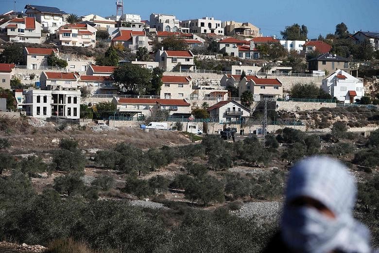 A Palestinian protester in front of an Israeli settlement earlier this month during clashes with Israeli security forces. The US abstention in the vote on the UN resolution could increase Israel's isolation over the paralysed peace process with its P