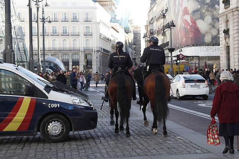 Above: Police at the Christmas market in Tours, central France. Left: Spanish police patrolling the Puerta del Sol public square on horseback in Madrid last Friday.
