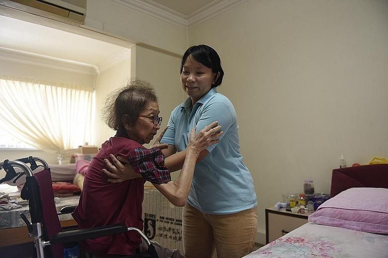 Myanmar live-in caregiver Than Than Sint helps Madam Tan Ah Sian, who has terminal gall bladder cancer, with daily activities like using the toilet.