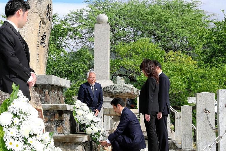 Mr Abe placing a wreath at a Japanese cemetery in Honolulu on Monday with Ms Tomomi Inada, Japan's Defence Minister. The Japanese Prime Minister, who was to visit Pearl Harbour with Mr Obama yesterday (today, Singapore time), called US-Japan relation