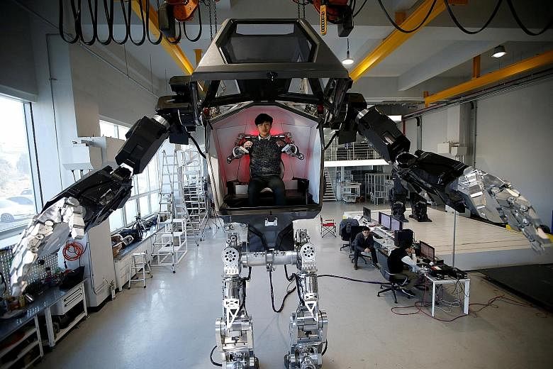 An employee controlling the arms of a manned biped walking robot METHOD-2 during a demonstration in Gunpo, South Korea. The company behind the 4m-tall humanoid says it is the largest biped robot in the world.