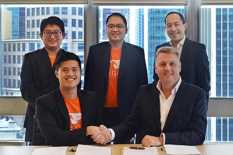 Savills' Mr Marriott with Pegaxis' Mr Poh, while behind them are (from left) Mr Lim Jun Rong and Mr Jacky Chong, co-founders of Pegaxis; and Mr Steven Ming, managing director at Savills Singapore. Last month, Savills increased its stake in Pegaxis fr