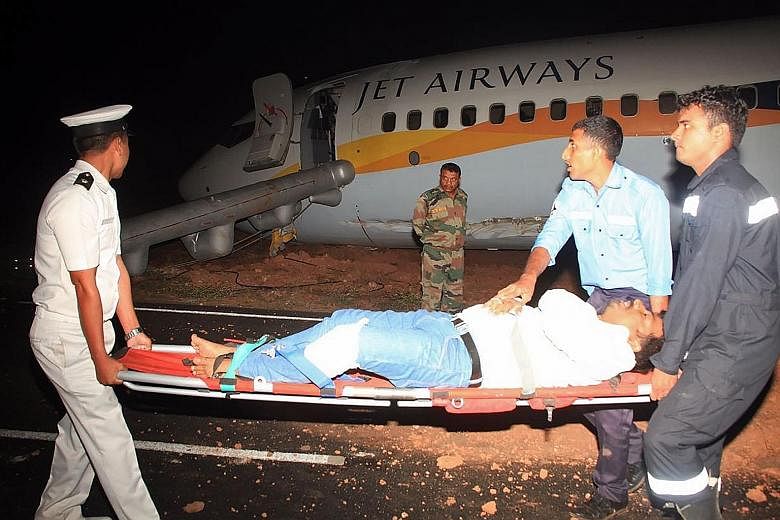 Top: The Jet Airways plane appears to have lost its front undercarriage and damaged a wing. Above: A dozen people on the Mumbai-bound flight were injured.