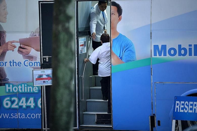 The TB screening at Block 203, Ang Mo Kio Avenue 3, included a blood test done at the void deck and an X-ray taken in a medical services bus (above) in the carpark. Residents of Block 203, Ang Mo Kio Avenue 3, undergoing TB screening in June. The scr