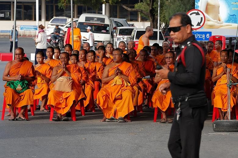 Monks praying on Tuesday at the gate of the Dhammakaya temple, whose abbot is the scandal-plagued Phra Dhammachayo.