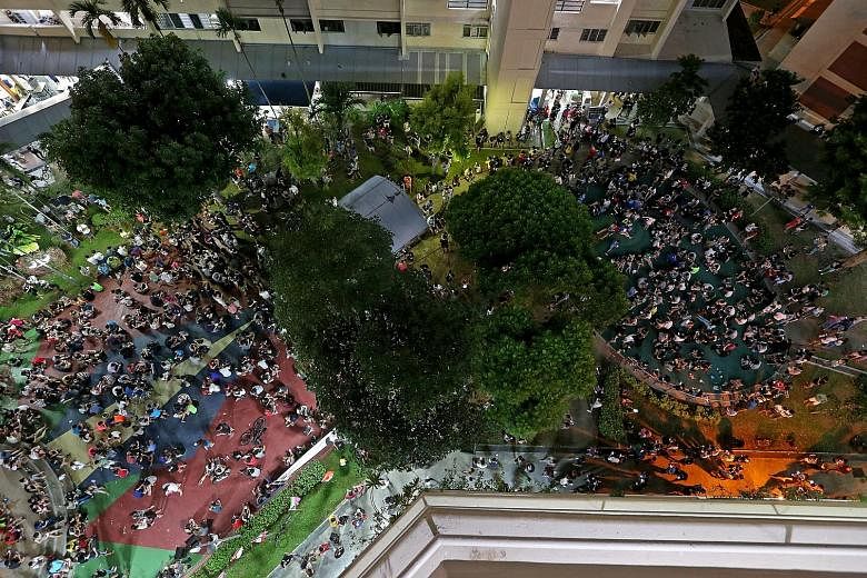 Above: Crowds of people playing Pokemon Go in Hougang Avenue 10 on Aug 13. Left: Pokemon Go players engrossed in the game in Orchard Road.
