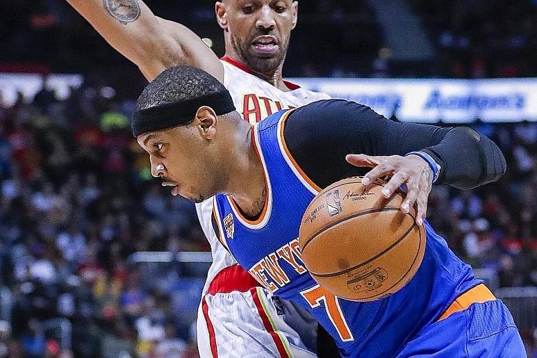 New York Knicks' Carmelo Anthony (front) driving against Atlanta Hawks' Thabo Sefolosha during the first half of the NBA game at Philips Arena in Atlanta. Anthony was ejected in the second quarter after he elbowed Sefolosha in the face.