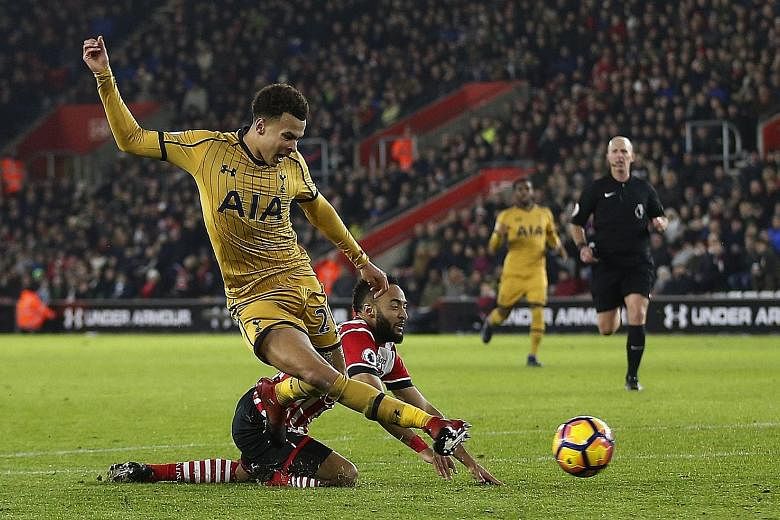Southampton's Nathan Redmond (in red) conceding a penalty against Tottenham's Dele Alli in their Premier League match on Wednesday. Below: Harry Kane missed the resulting penalty, but his team ultimately won 4-1 with Alli scoring twice.