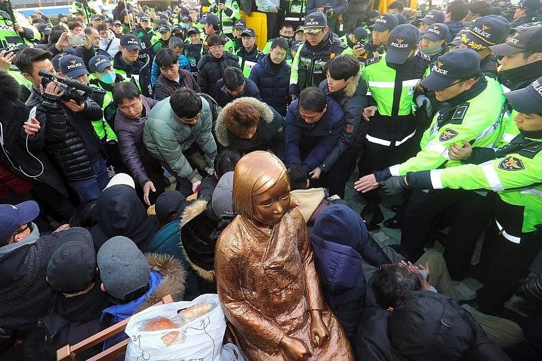 South Korean activists staging a sit-in protest on Wednesday to stop government employees from seizing the "comfort woman" statue outside the Japanese consulate in Busan. The authorities now say they will not stop activists from setting up the statue