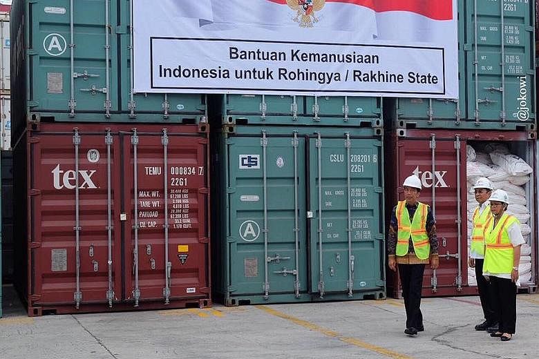 Indonesian President Joko Widodo (in batik shirt) inspecting an aid consignment destined for Myanmar's Rakhine state at the Tanjung Priok Port on Thursday. Ten freight containers filled with instant noodles, baby food, wheat, cereals and sarongs were
