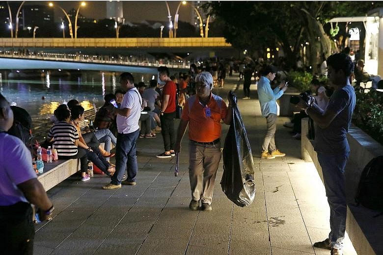 A cleaner at the Esplanade waterfront after the countdown in Marina Bay, where massive crowds had gathered to watch the annual fireworks. Volunteers gave out free trash bags throughout the evening.