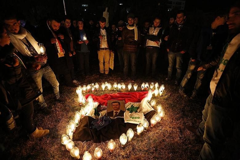 Candles arranged in the shape of the Syrian map surround a picture of President Bashar al-Assad during a vigil for peace at the Umayyad Square in Damascus. The vigil was held last Friday. A nationwide truce has been threatened by continued fighting i