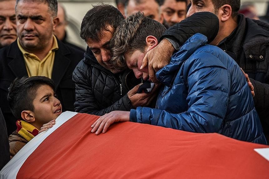 Relatives of Mr Ayhan Arik, one of the victims of the Reina nightclub shooting, mourning during his funeral in Istanbul on Sunday. Thirty-nine people, most of them foreigners, were killed early on Sunday when a gunman went on a rampage at the swanky 