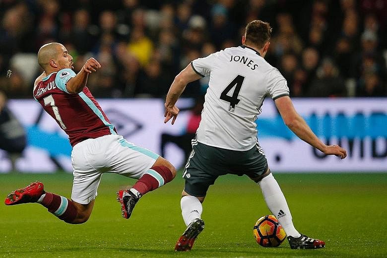 West Ham midfielder Sofiane Feghouli leaping in to challenge United defender Phil Jones. The Algerian is sent off for the tackle after he catches his opponent on the follow- through.
