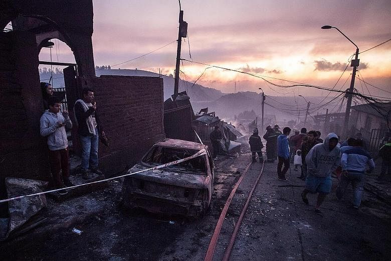 A wildfire has ravaged woods and burned 100 houses in the hilly Chilean port city of Valparaiso, forcing the authorities to evacuate hundreds of people. At least 19 people were reported hurt after the fire broke out on Monday on the outskirts of the 