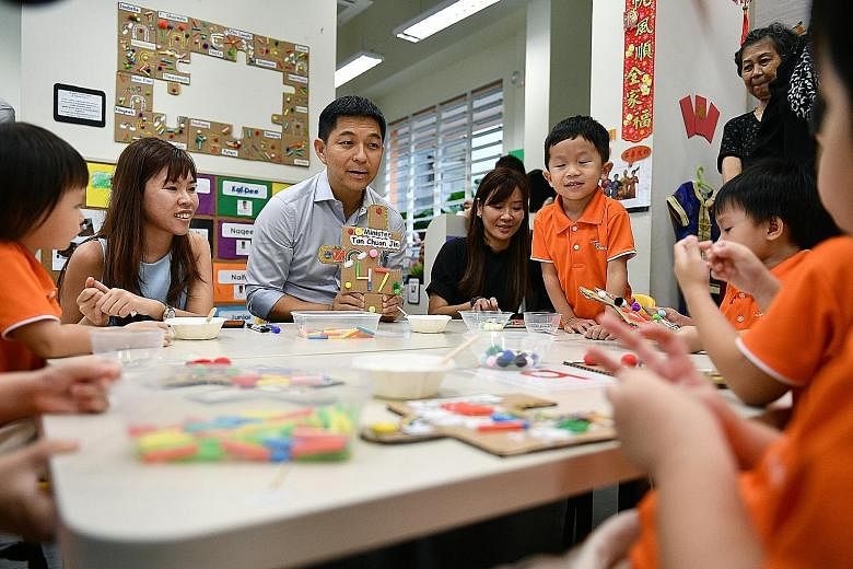 Minister for Social and Family Development Tan Chuan-Jin interacting with pre-schoolers at Mr First Skool in Boon Lay Drive yesterday. With him are Ms Nicole Kin (left) and Ms Celia Teo, principal of the pre-school.