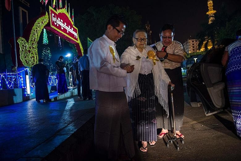 Myanmar held state ceremonies yesterday in Naypyitaw and Yangon to mark the country's 69th Independence Day. Here, independence veteran Nyin Nay, 92, is assisted by relatives after a dawn flag-raising ceremony in Yangon yesterday.