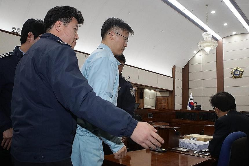 An (in olive green attire) and Jeong (in light blue attire), both former presidential aides, appearing ink court yesterday alongside Choi. They face charges including misuse of power.