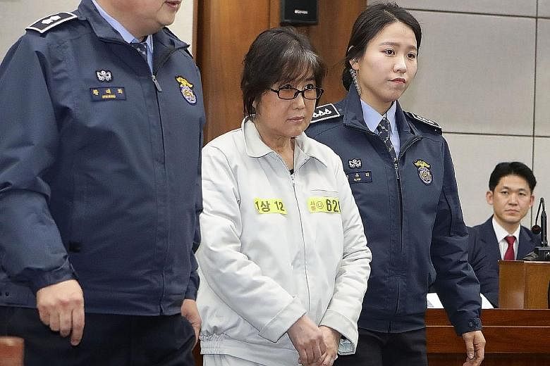 Choi (in beige) appearing on the first day of her trial at the Seoul Central District Court yesterday. She is accused of colluding with Ms Park, whose powers have been suspended, to pressure big businesses into contributing to non-profit foundations 