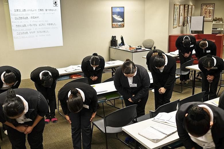 Trainees are taught to bow at a training centre in Manila, in preparation for their work as housekeepers in Japan.