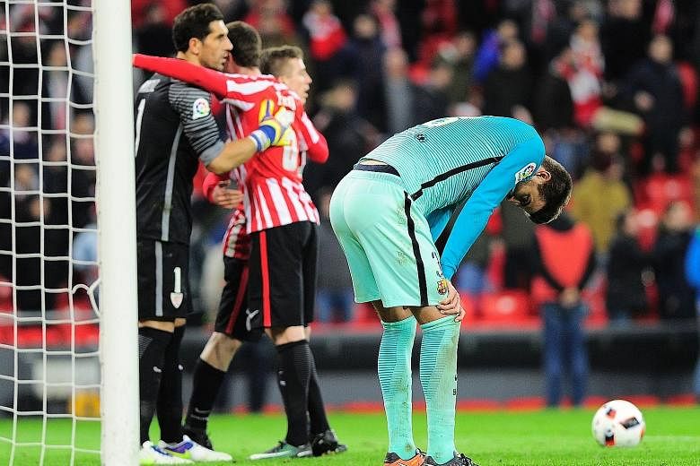 Barca defender Gerard Pique bends over in disappointment, as Bilbao celebrate their 2-1 win in the first leg of the Spanish King's Cup last-16 tie. They will hope to be sixth time lucky after never beating their rivals in their last five Cup meetings