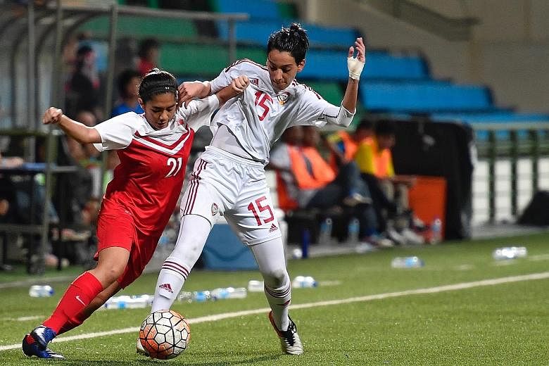 Singapore's Stephanie Dominguez (left) vying for the ball with the United Arab Emirates' Afra Almheiri in a 0-0 friendly draw at Jalan Besar Stadium last night.