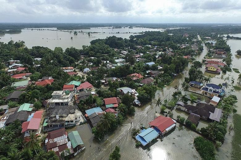 Kampung Jal Besar in Malaysia's north-eastern town of Tumpat, in Kelantan, remained under water yesterday despite the heavy rain stopping. The east coast states are sitting out the floods that have inundated various areas, with thousands of residents