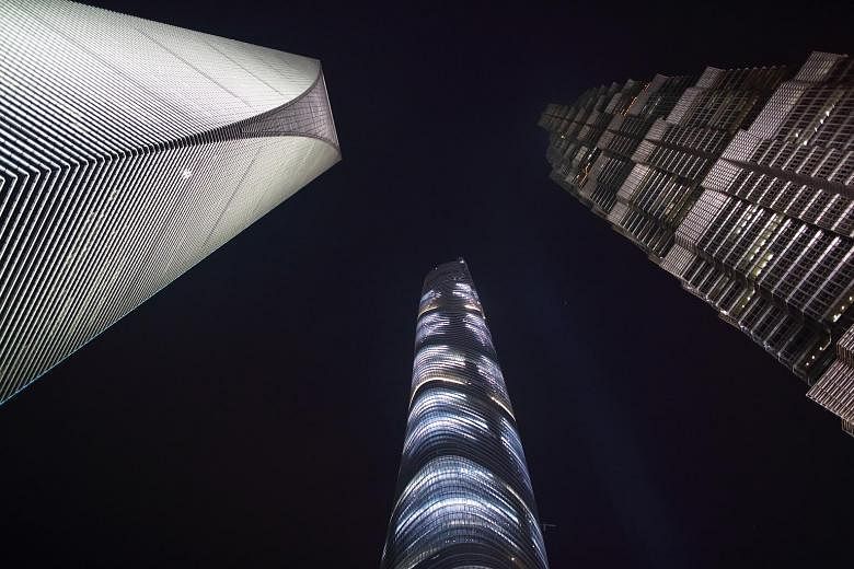 The lifts in Shanghai Tower (centre), made by Japanese firm Mitsubishi Electric, are the fastest in the world.