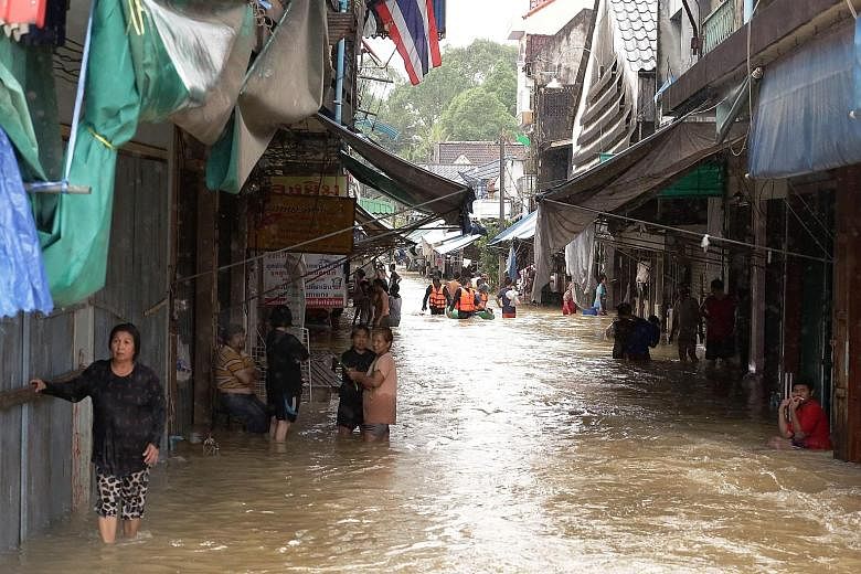 This village (above) in the southern Thai district of Cha-uat is among thousands hit by floods. Rescue teams have been mobilised to evacuate residents (below).