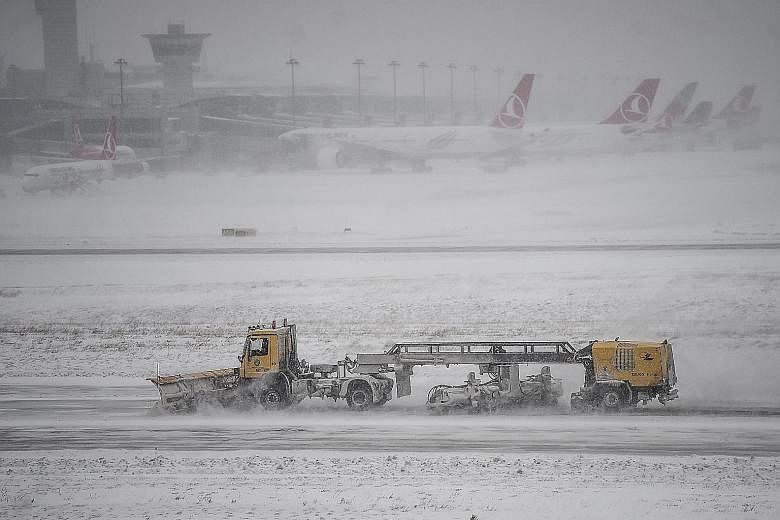 A snowplough clearing away the snow at Ataturk international airport in Istanbul on Saturday. Turkish Airlines' weekend flights between Singapore and Istanbul were among those cancelled.