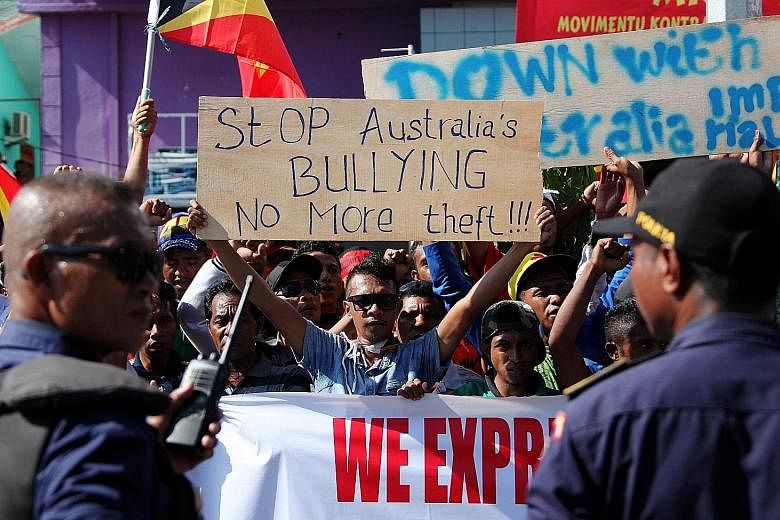 The two countries will negotiate a permanent maritime boundary in place of an old treaty that had caused unhappiness in Timor Leste, with students (above) protesting outside the Australian embassy in Dili. Experts say the new border is likely to be m