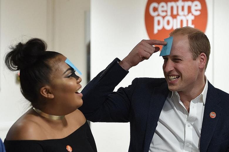 Britain's Prince William playing a guessing game with 22-year-old Sherihan Sharis, during a visit to a Centrepoint hostel in London on Tuesday. The Duke of Cambridge is the patron of Centrepoint, a charity for homeless young people between 16 and 25 