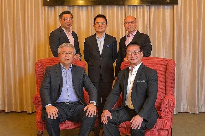 Mr Thomas Chua (seated left), president of the 58th Council, and Mr Roland Ng, the new president. Standing, from left: Vice-presidents Kuah Boon Wee, Wu Hsioh Kwang and Charles Ho Nai Chuen.