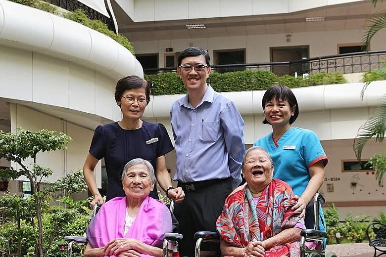 Left: (From far left, standing) Nurse manager Lee Tiang Hong, All Saints Home CEO Michael Tay and senior staff nurse Naw Paw Ray with Tampines centre residents Tan Lai Ho (far left), 86, and Kwan Soh Ying, 78. Below: Ms Naw Paw Ray, seen with residen