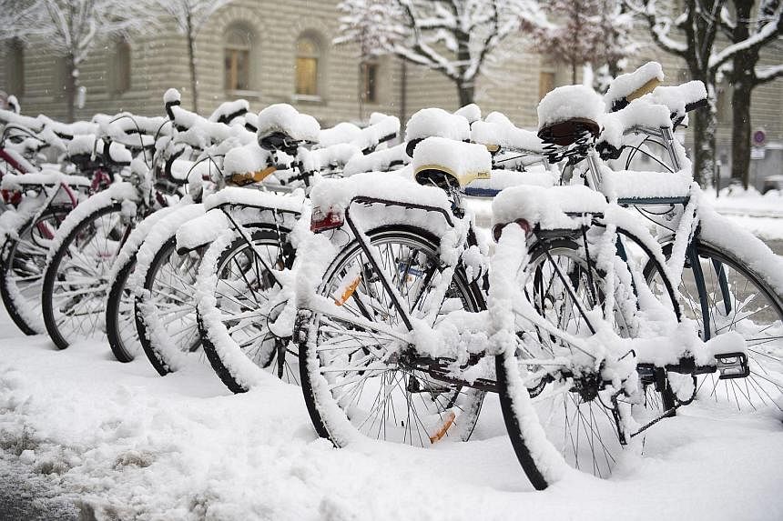 Bicycles sit unused along a street in Bern. The heavy January snowfall comes after a long absence of snow in Switzerland, where the fickle winter weather has left some ski resorts with closed slopes and a drop in tourist numbers.