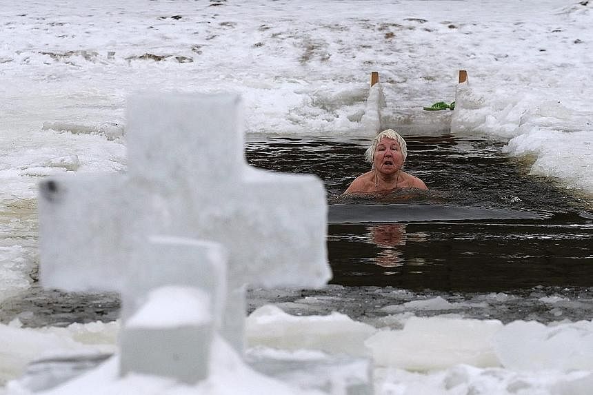 An elderly bather braving the ice in the Neva River in St Petersburg, where temperatures were around 0 deg C. 