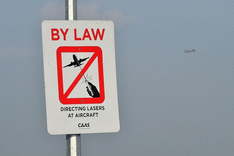 Laser lights that are shone into a plane's cockpit can confuse or distract pilots. This is especially dangerous during take-off and landing. A sign at Bedok Jetty (far right) forbids people to aim laser pointers at planes.