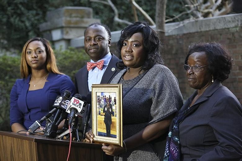 Ms Rose Ann Simmons holding a portrait of her father, Reverend Daniel Simmons, who was shot dead by Roof (below). With her are (from left) Rev Simmons' granddaughter Alana, son Daniel Simmons Jr and wife Annie.
