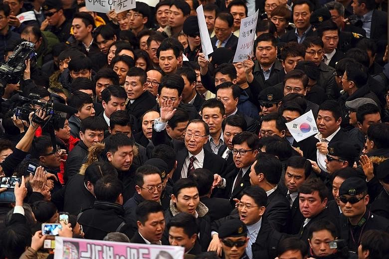 At Incheon International Airport, west of Seoul, yesterday, Mr Ban (centre, with glasses and with hand raised) was greeted by hundreds of supporters. However, his return has also drawn media scrutiny of his credentials.