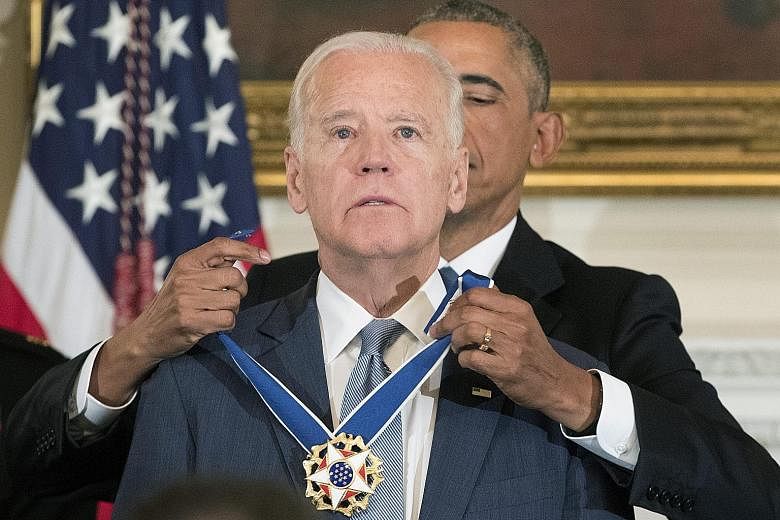 Mr Obama putting the Presidential Medal of Freedom with Distinction on Mr Biden in the White House on Thursday.