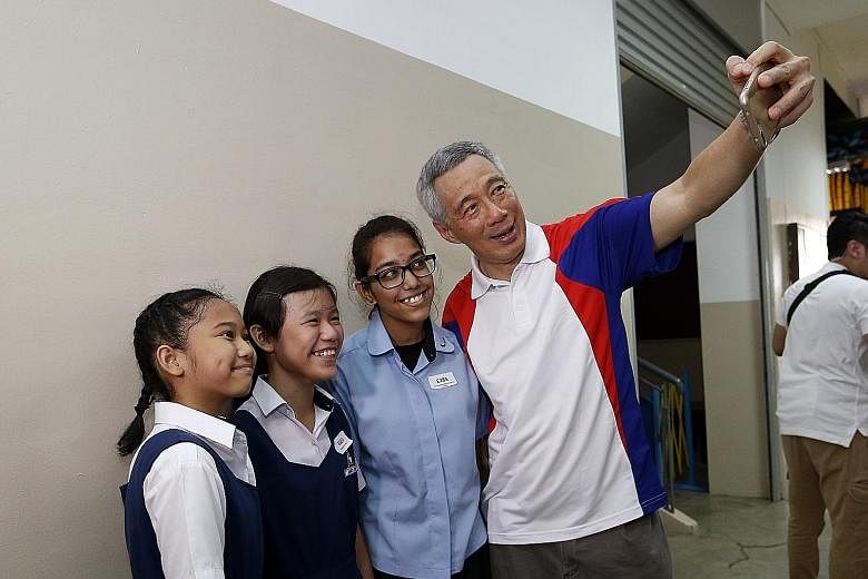PM Lee taking a wefie with (from left) Primary 6 pupil Dyan Nurqalisya Nurazhar, Primary 5 pupil Janece Yong and Uma Maheswari Selva Kumar, who is entering Nanyang Polytechnic. All three received Edusave awards yesterday.