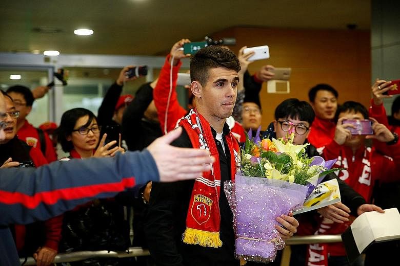 A throng of fans welcoming Brazil midfielder Oscar at Shanghai Pudong International Airport. He is set to earn around £400,000 a week with Shanghai SIPG after joining from Chelsea.