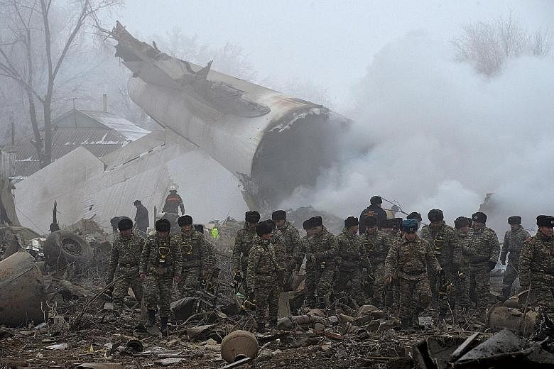 Rescuers going through the crash site of a Turkish cargo plane in the village of Dacha-Suu, outside the Kyrgyz capital of Bishkek, yesterday. At least 37 people, most of them residents of the village, were killed. A Boeing 747-400 from ACT Airlines, 