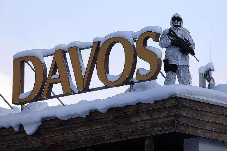 An armed member of the Swiss Police standing guard on the roof of the Hotel Davos yesterday, ahead of the World Economic Forum in Davos, Switzerland. The annual conference to seek solutions to society's biggest problems will hold its discussions this