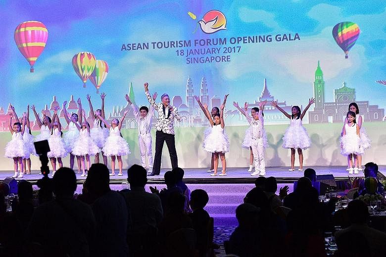 Composer Dick Lee performing the song Rise with children from the Kids Performing Academy of the Arts at the Asean Tourism Forum yesterday. The Visit Asean@50 campaign coincides with Asean's 50th anniversary and will feature the region's 50 best fest