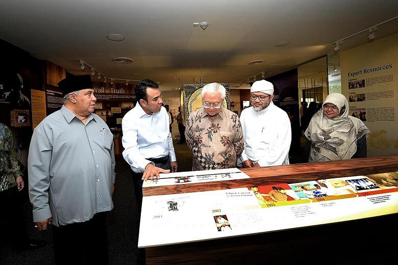 President Tan with leaders and members of the Religious Rehabilitation Group - (from left) Ustaz Ali Mohamed, Ustaz Mohamed Ali, Ustaz Hasbi Hassan and Ustazah Kalthom Muhammad Isa - during a tour of the group's resource and counselling centre at Kha