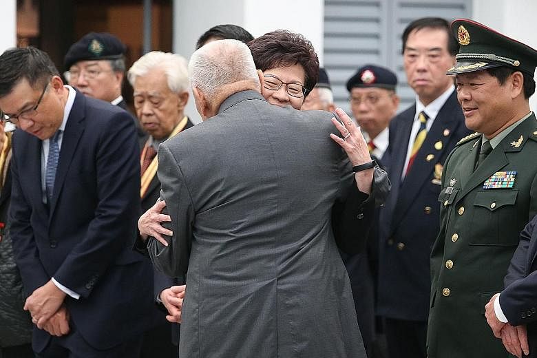 Former chief executive Mr Tung hugging Mrs Lam last month. Mrs Lam says Mr Tung has stopped his usual practice of hugging her to avoid speculation that she has been favoured for the chief executive job.